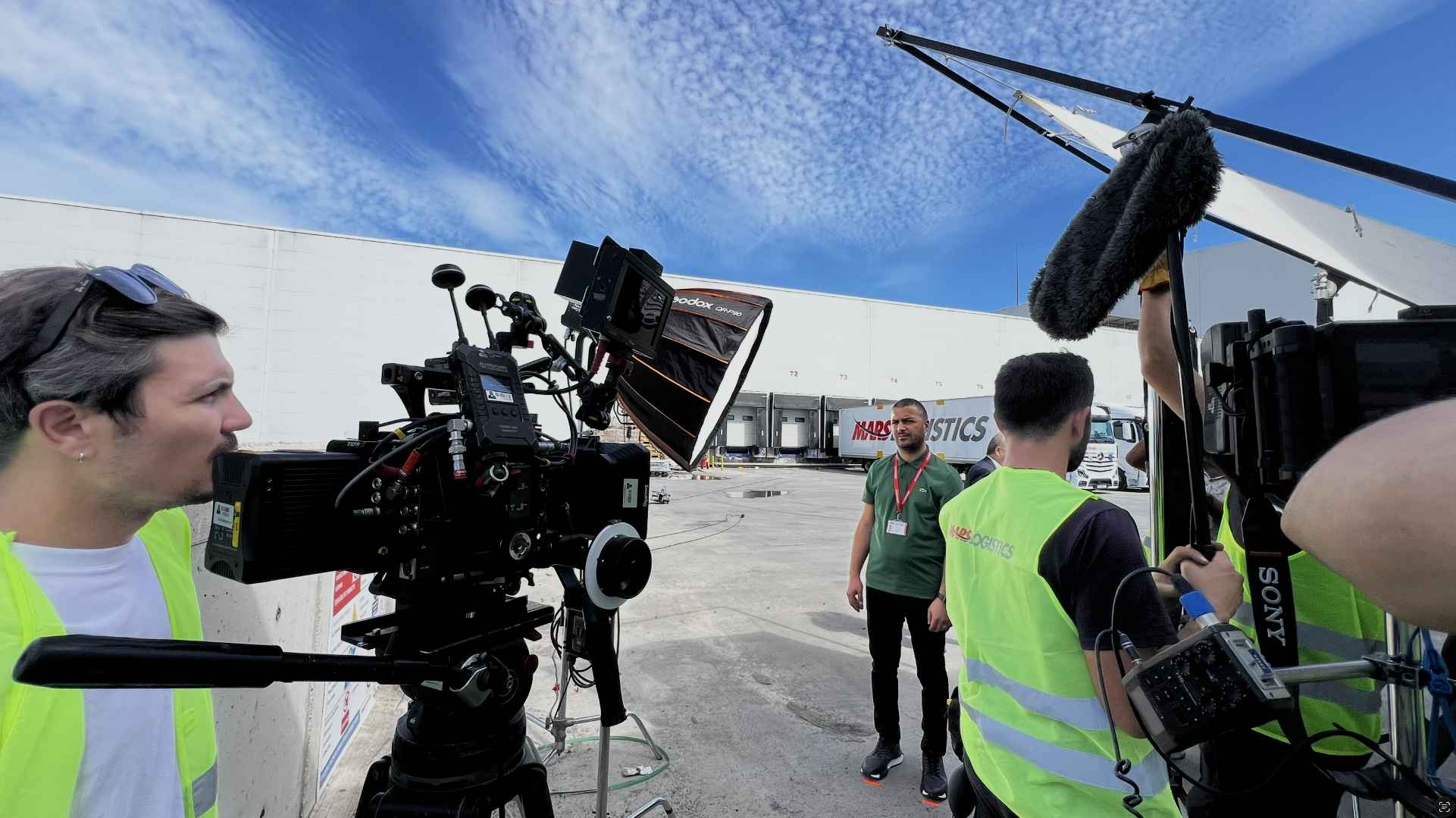Film crew documenting work on location at a logistics facility.