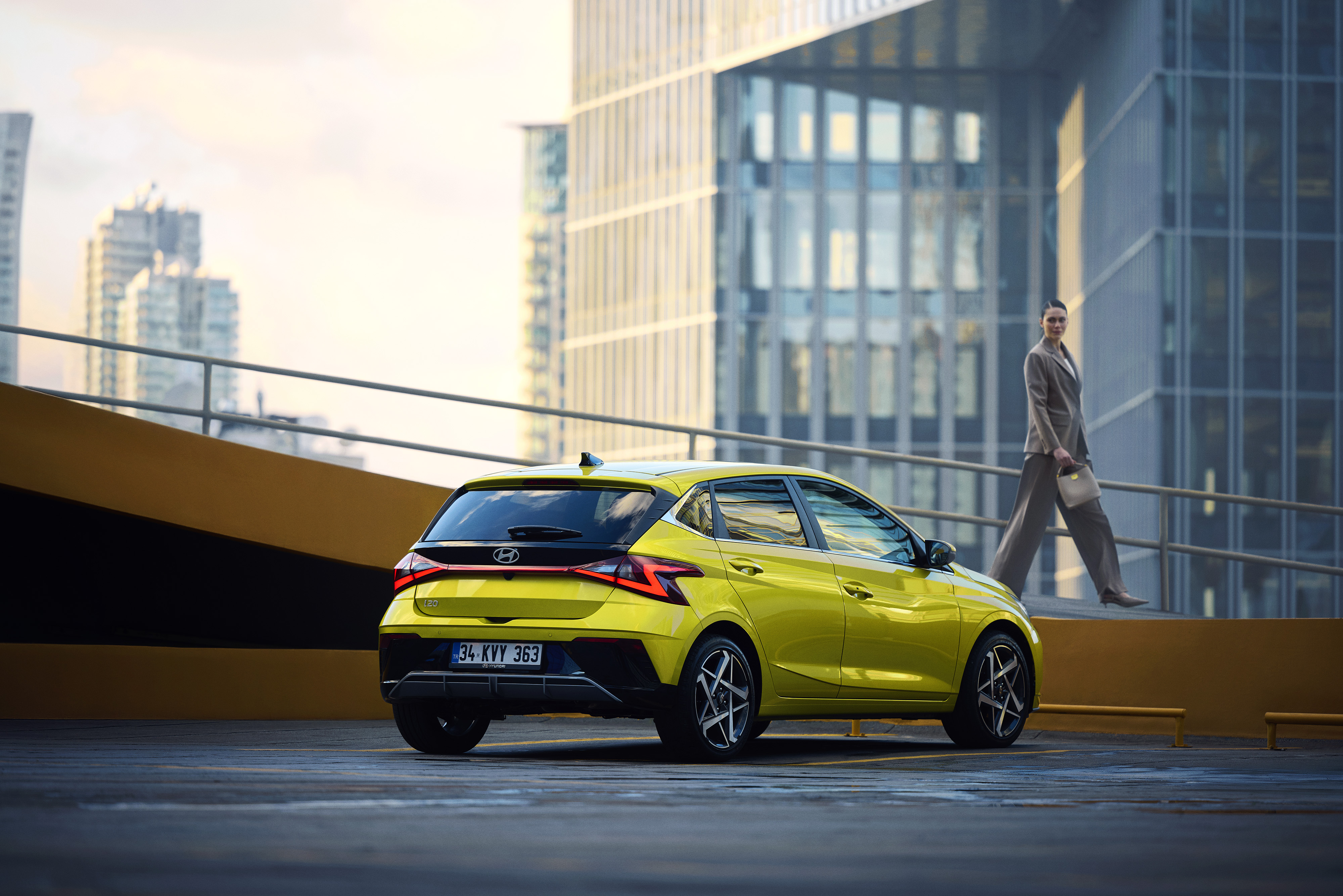 Yellow Hyundai i20 photographed in an architectural city setting.
